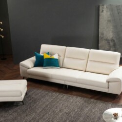 Sofa FORMORY màu kem ngà, dáng văng 3 chỗ ngồi kết hợp đôn rời, được chụp từ góc hơi chếch phía trước. Sofa đặt trên thảm…