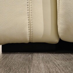 Cận cảnh phần chân ghế và cạnh dưới của sofa SF8138, thể hiện sự kết hợp hài hòa giữa chất liệu da bò màu kem và chân đế m…