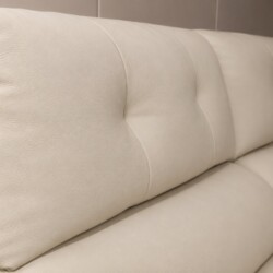 Một góc chụp khác của phần tựa lưng ghế sofa SF8138, làm nổi bật độ dày và sự mềm mại của lớp đệm bọc da bò màu kem. Các đ…