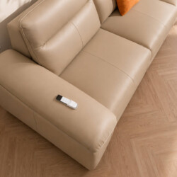 Cận cảnh phần tay vịn và góc của sofa chỉnh điện CALISTA SF2887 màu be nhạt. Bề mặt da bò tự nhiên mềm mại, có nếp nhăn nh…