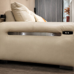 Cận cảnh phần hông của sofa AUREO màu kem nhạt, làm nổi bật chi tiết nút điều khiển điện tiện lợi. Thanh kim loại sáng bón…