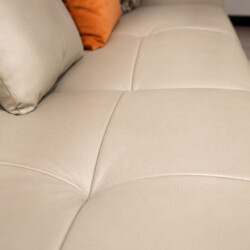 Cận cảnh góc đệm ngồi của sofa AUREO màu kem nhạt, với các đường may vuông vắn, chắc chắn, tạo nên vẻ đẹp hiện đại. Chiếc…