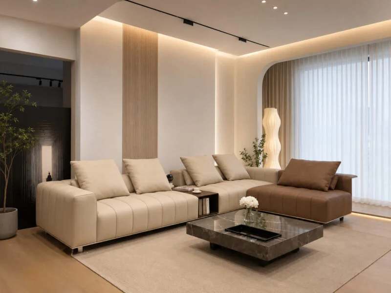 Bộ sofa góc L SERENITY SBH361 màu kem và nâu da bò, đặt trong không gian phòng khách hiện đại luxury. Sofa có thiết kế tha…