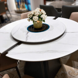 Cận cảnh mặt bàn ăn ARDEN thông minh trong trạng thái kéo dài một phần, cho thấy rõ các khớp nối linh hoạt. Mặt bàn đá trắ…
