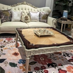 Cận cảnh ghế sofa băng hai và bàn trà của bộ PALAIS D'OR, nổi bật với lớp da bò tự nhiên màu kem và các chi tiết chạm khắc…
