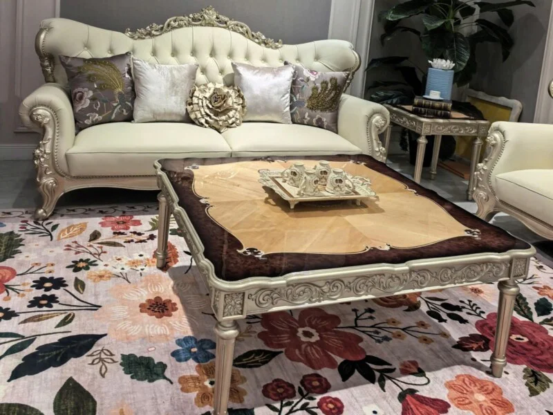 Cận cảnh ghế sofa băng hai và bàn trà của bộ PALAIS D'OR, nổi bật với lớp da bò tự nhiên màu kem và các chi tiết chạm khắc…