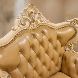 Cận cảnh chi tiết tay vịn của sofa đơn Royal Crown SB982H. Các đường nét chạm khắc hoa văn uốn lượn màu kem trên khung gỗ…