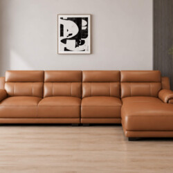 Sofa góc L VENTO màu nâu caramel, chụp chính diện từ góc thấp, nổi bật với thiết kế hiện đại, các múi đệm phồng tạo cảm gi…