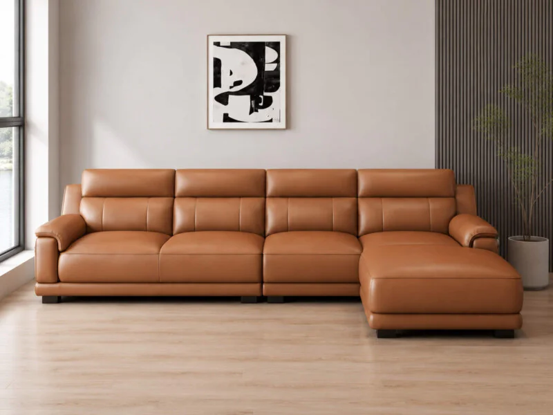 Sofa góc L VENTO màu nâu caramel, chụp chính diện từ góc thấp, nổi bật với thiết kế hiện đại, các múi đệm phồng tạo cảm gi…