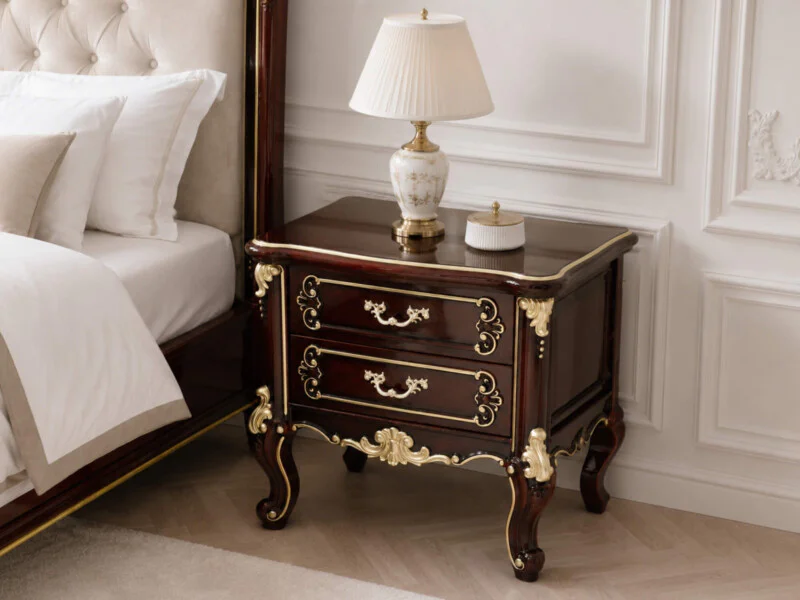 Tủ đầu giường Versailles A15 phong cách tân cổ điển, đặt cạnh giường ngủ bọc nệm màu kem. Tủ có hai ngăn kéo, màu nâu đỏ b…