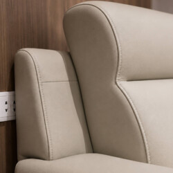 Cận cảnh phần tựa lưng cong mềm mại của sofa COASTAL II, bọc da công nghiệp màu be nhạt. Chi tiết đường may tinh xảo và độ…