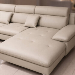 Sofa góc COASTAL II bọc da công nghiệp màu be nhạt, chụp từ góc thấp phía trước bên phải. Thiết kế tay vịn thấp, tựa lưng…